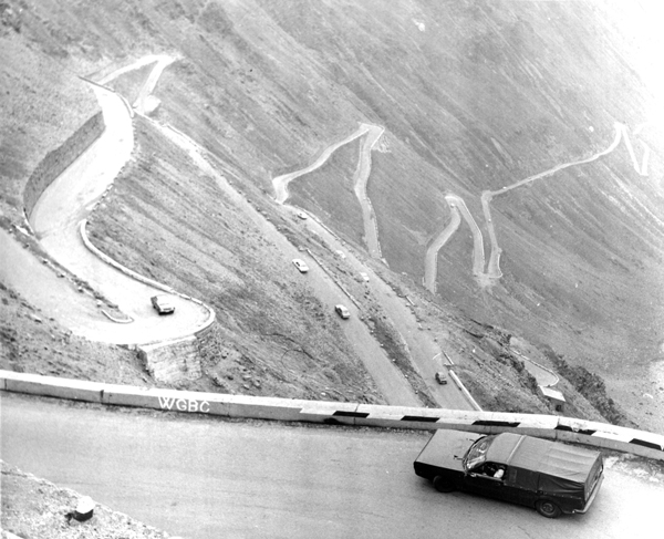 aerial view of camouflaged car on mountain hair-pin bend