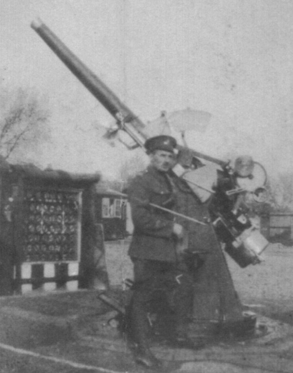bombardier with baton standing next to anti-aircraft gun