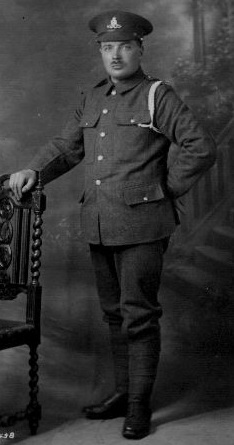 formal photograph of man in royal artillery uniform standing against a chair