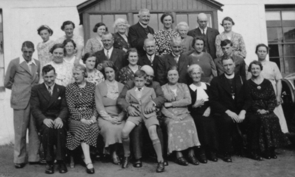 family group in front of farm house