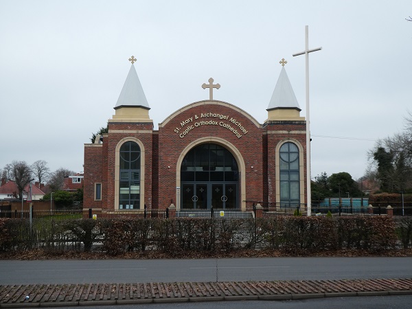 front view of coptic cathedral flanked by tall white cross