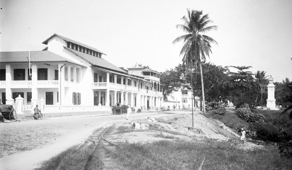 long two-storey building and palm trees